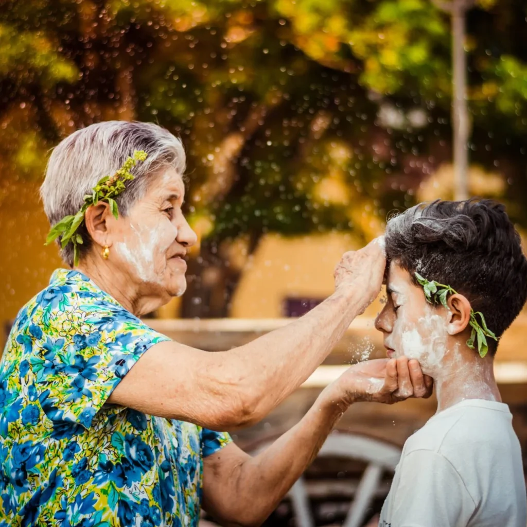 Abuela chayando junto a su nieto durante la Chaya en Chilecito, La Rioja, celebración popular llena de música, harina y tradición.